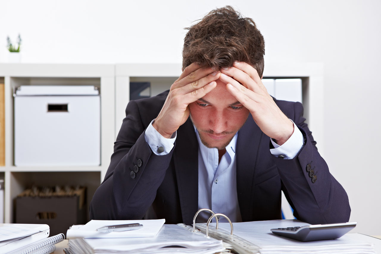 Business man in office with burnout syndrome at desk