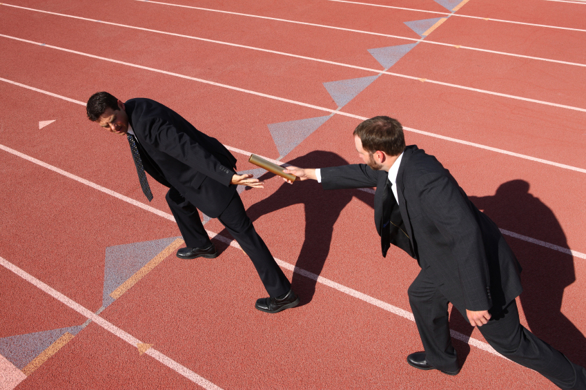 business men passing the baton on track field - building bench strength