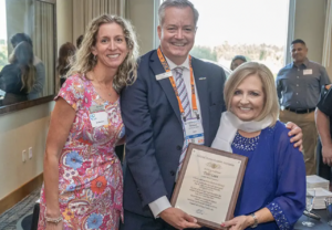 Jo Damato, Doug Carr present Debbi Laux with the Silk Scarf award at NBAA-BACE 2022