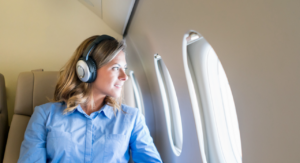 Female business traveler looking out the window on jet - AINsight article by Sheryl Barden on unifying business travel management