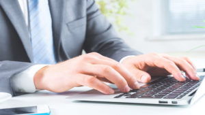 Businessman typing on laptop keyboard