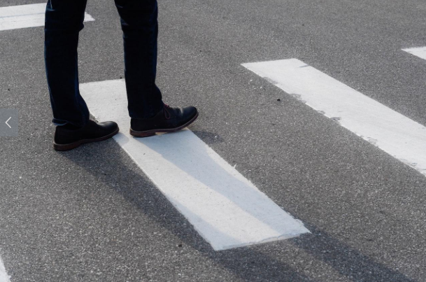 man walking across street - implies career crossroads - aviation personnel