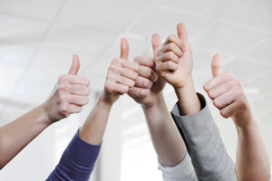 employee hands with thumbs in air signifying employer of choice
