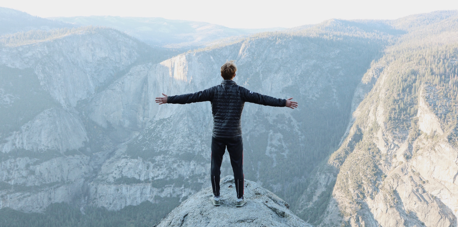 man on mountain top reflecting on annual report and decade in review